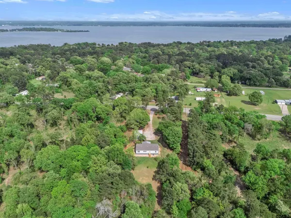 an aerial view of a houses with a yard and lake