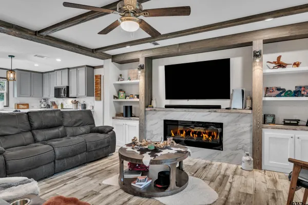 a living room with furniture a fireplace and a flat screen tv