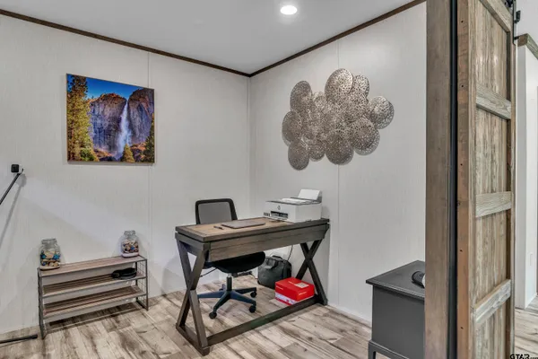 a view of a hallway with workspace and a couch