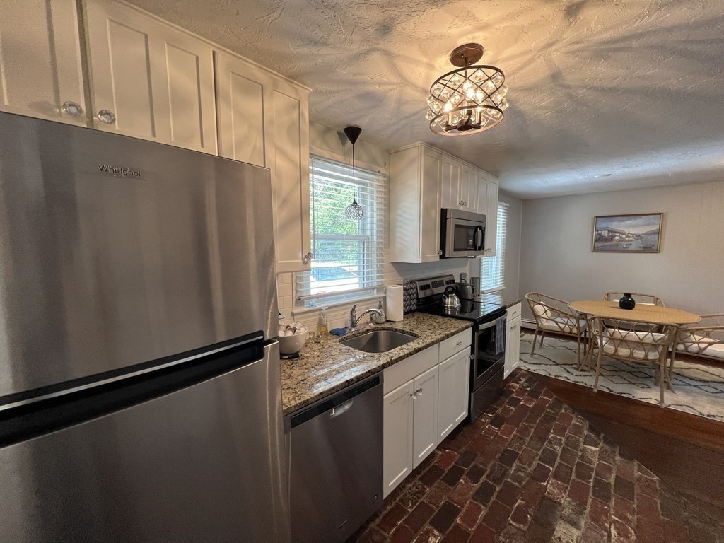 12 State Road, Unit 2E Plymouth, MA 02360 - Photo 3 of 28 a kitchen with granite countertop stainless steel appliances a sink stove top oven and cabinets
