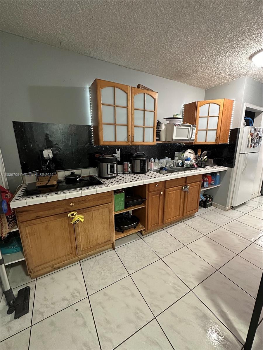 16901 Northwest 51st Place, Unit C Miami Gardens, FL 33055 - Photo 5 of 13 a kitchen with stainless steel appliances granite countertop a stove a sink and a microwave
