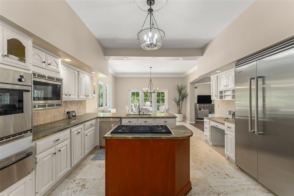 9731 Chestnut Ridge Drive Windermere, FL 34786 - Photo 12 of 57 a kitchen with stainless steel appliances granite countertop a stove refrigerator and cabinets
