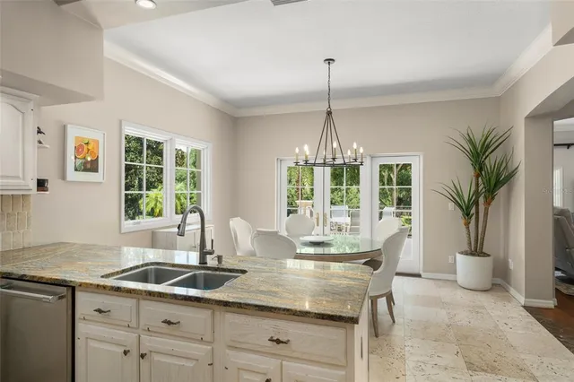 a kitchen with stainless steel appliances granite countertop a sink a stove and a wooden floors
