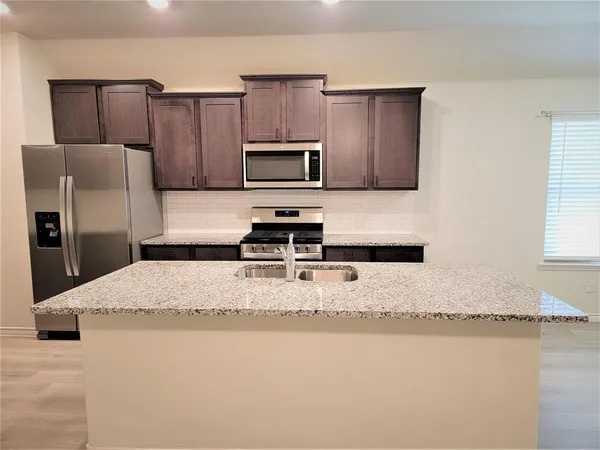 a kitchen with a refrigerator sink and microwave