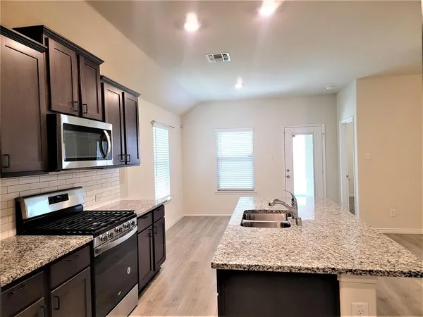 a kitchen with stainless steel appliances granite countertop a stove and a sink