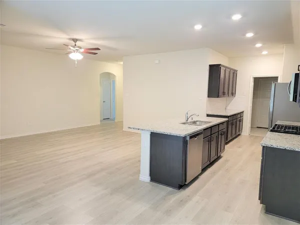 a kitchen with stainless steel appliances granite countertop a sink and a refrigerator