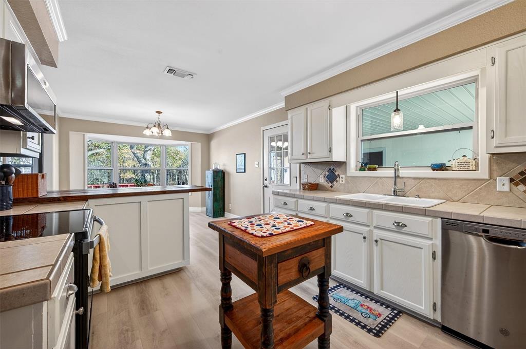 140 Harrell Road Howe, TX 75459 - Photo 19 of 40 a kitchen that has a sink a stove counter top space and a window in it
