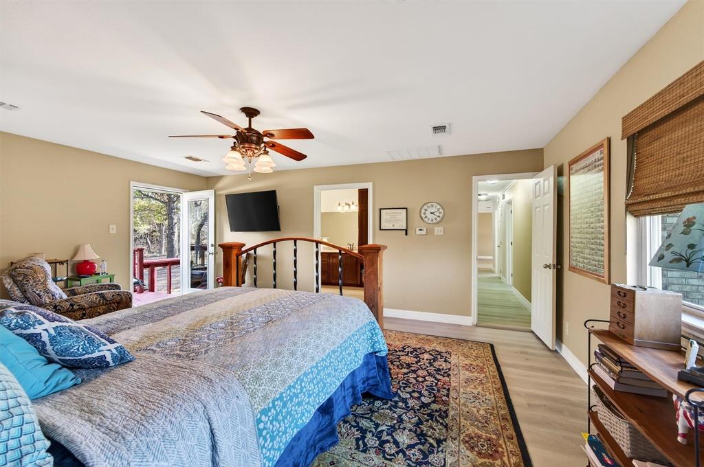 140 Harrell Road Howe, TX 75459 - Photo 21 of 40 a bedroom with a large bed and a chandelier