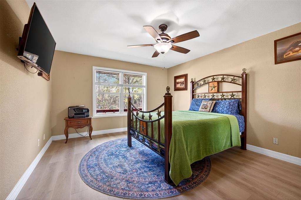 140 Harrell Road Howe, TX 75459 - Photo 28 of 40 a bedroom with a bed and a chandelier