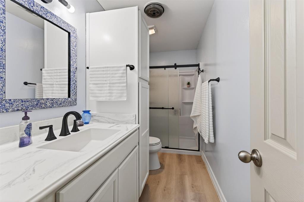 140 Harrell Road Howe, TX 75459 - Photo 30 of 40 a bathroom with a sink a toilet a mirror and shower