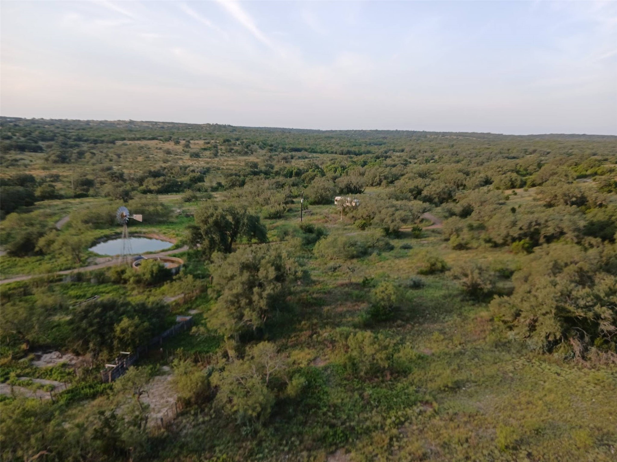 5 Dominion At Oak Ridge Junction, TX 76849 - Photo 1 of 34 Expansive natural landscape featuring a windmill, a water tank, and a pond