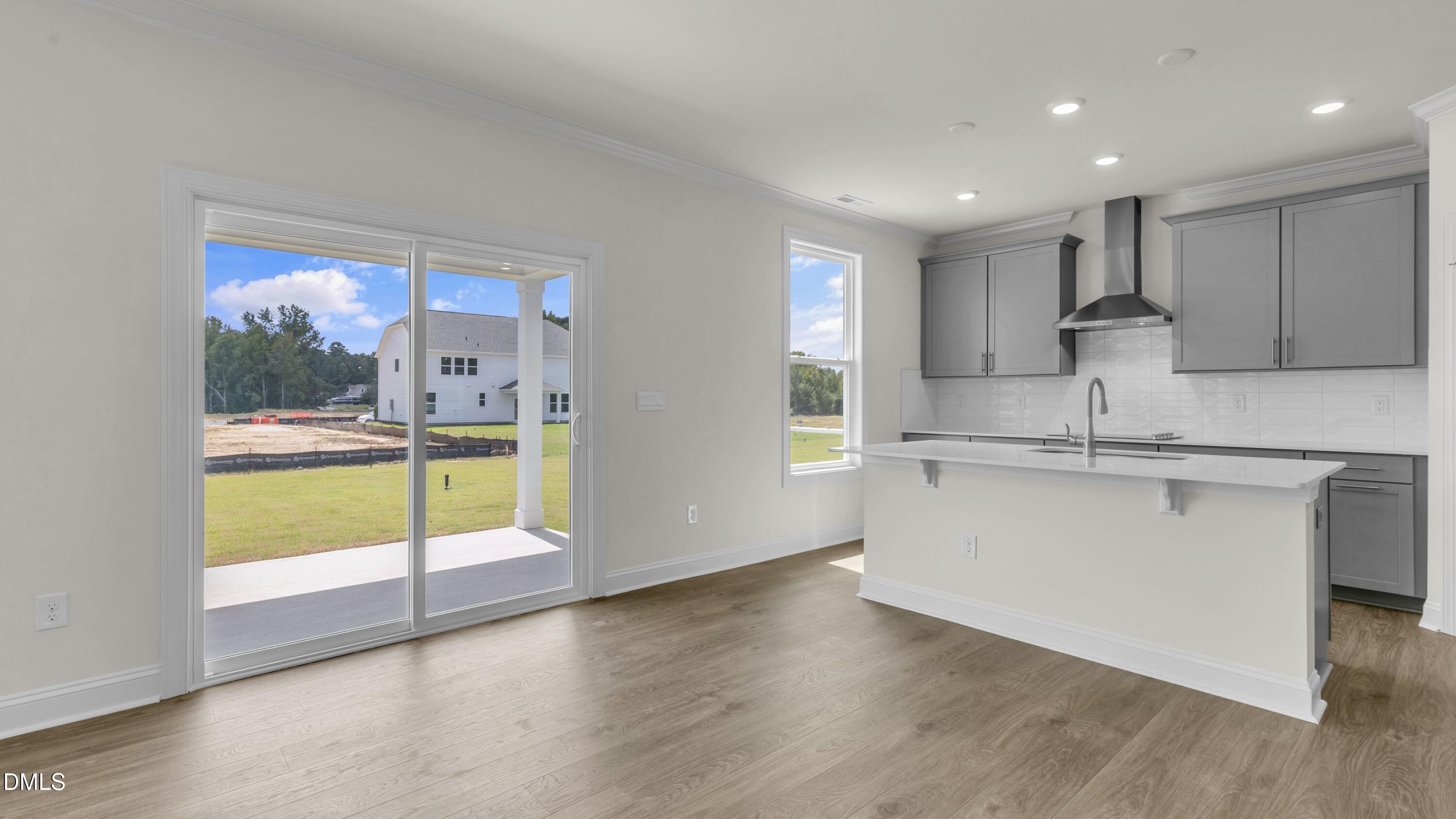 191 Gilmer Street Fuquay-Varina, NC 27526 - Photo 11 of 40 a kitchen with kitchen island a sink a stove and a window