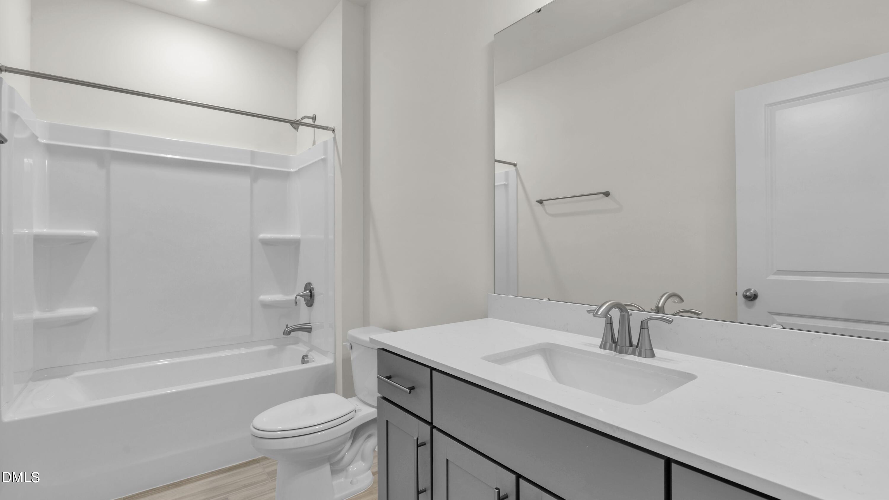 191 Gilmer Street Fuquay-Varina, NC 27526 - Photo 30 of 40 a bathroom with a sink toilet vanity tub and shower