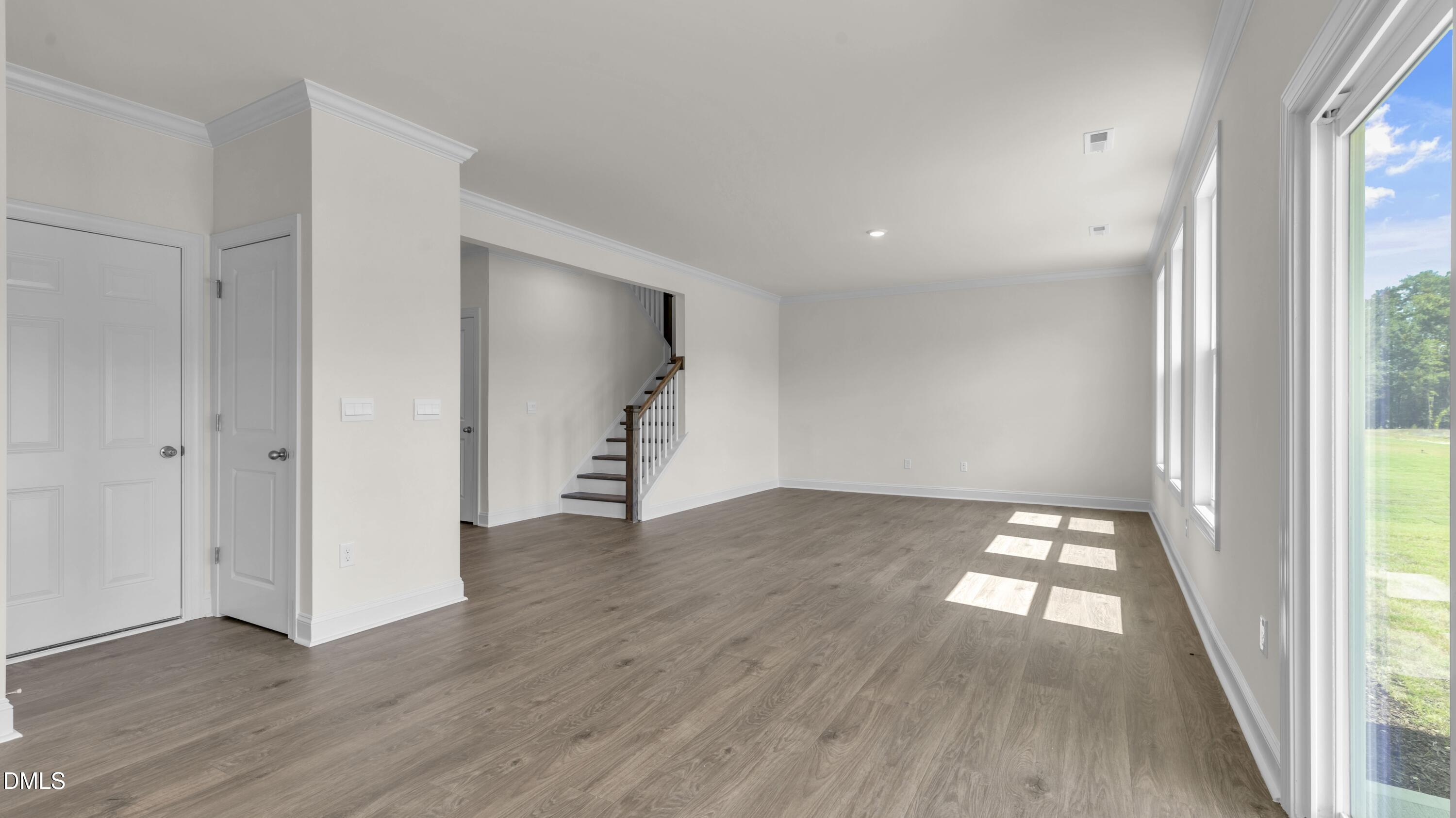 191 Gilmer Street Fuquay-Varina, NC 27526 - Photo 10 of 40 an empty room with wooden floor and windows