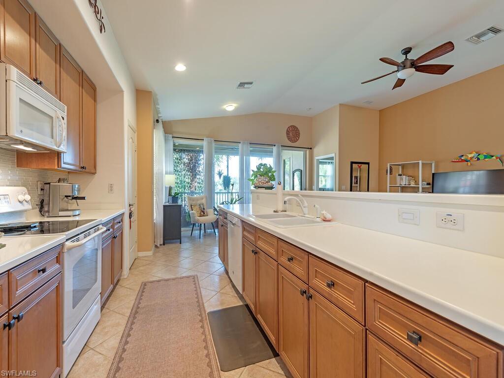 13000 Sandy Key Bend, Unit 3203 North Fort Myers, FL 33903 - Photo 4 of 25 Kitchen featuring coastal white appliances, lots of counterspace, cabinetry and a lofted ceiling, which opens to the living/dining areas of the home.