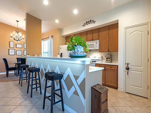 a large kitchen with a large counter top a sink stainless steel appliances and cabinets