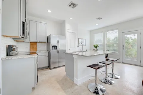 a kitchen with refrigerator and chairs