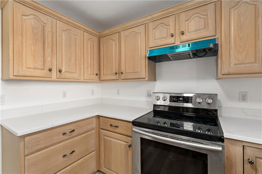 58 Locust Street McKees Rocks, PA 15136 - Photo 15 of 37 a kitchen with stainless steel appliances granite countertop white cabinets and a stove top oven