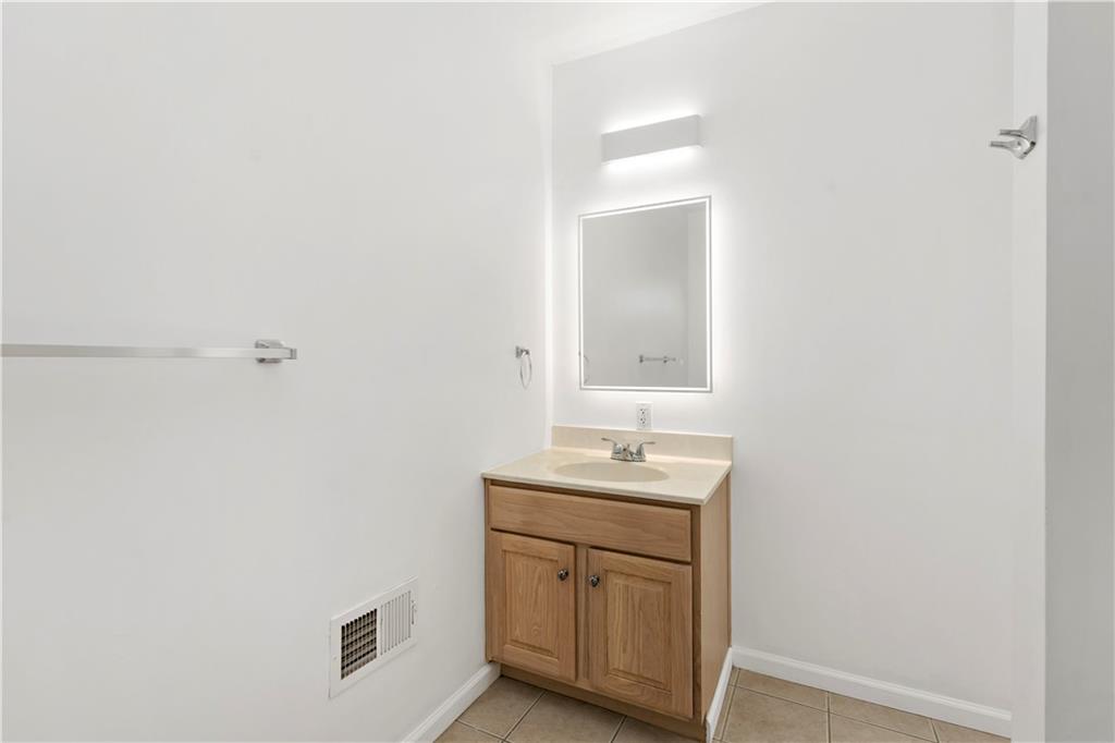 58 Locust Street McKees Rocks, PA 15136 - Photo 25 of 37 a bathroom with a sink a vanity and a mirror