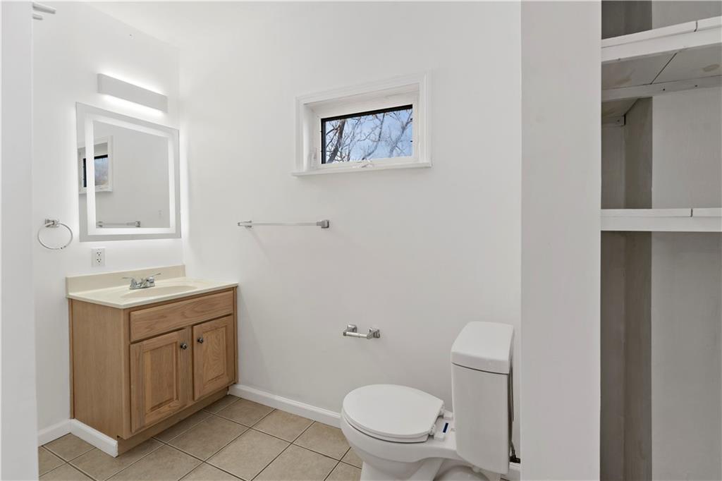 58 Locust Street McKees Rocks, PA 15136 - Photo 27 of 37 a bathroom with a toilet a sink a vanity and mirror