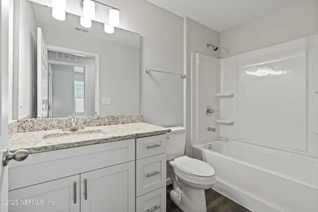 a bathroom with a sink toilet vanity and shower