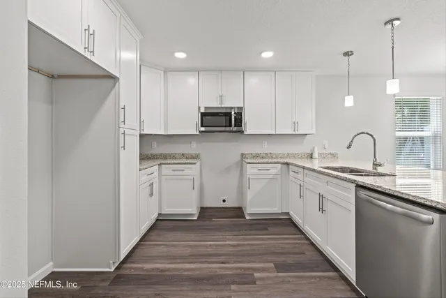 a kitchen with white cabinets and appliances