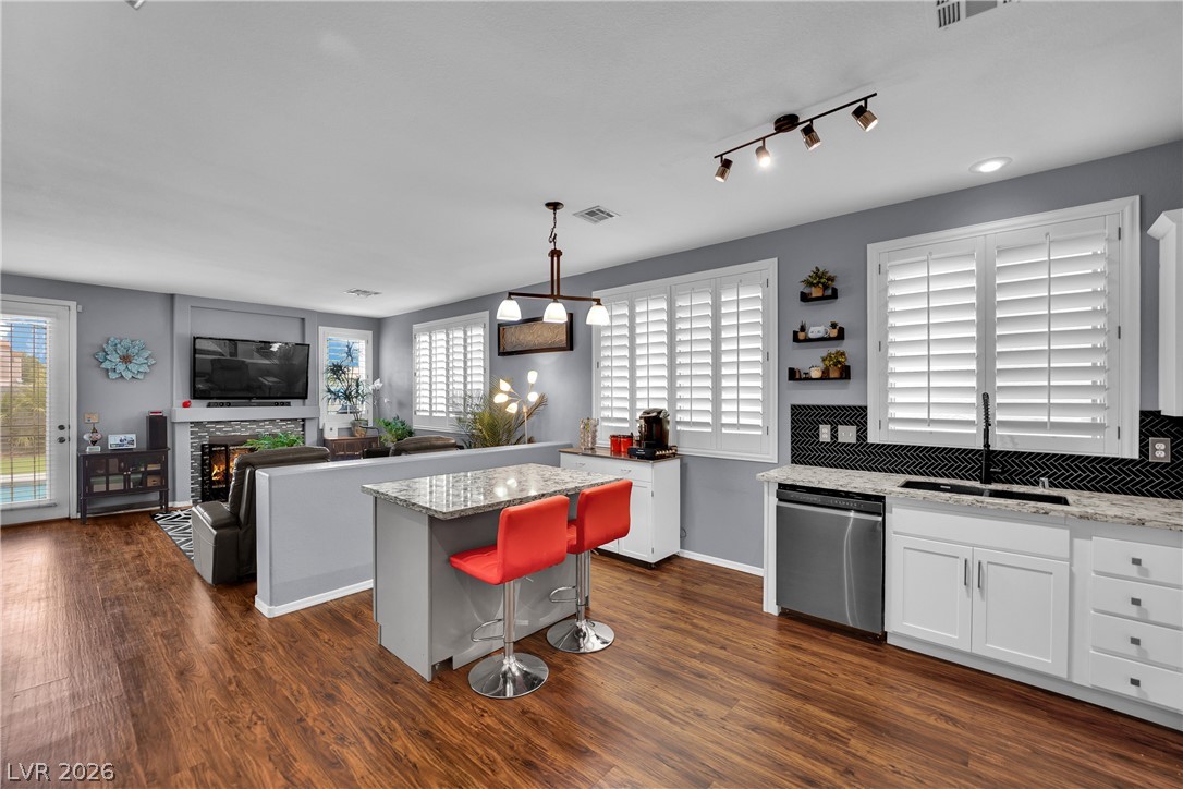 1724 Millstream Way Henderson, NV 89074 - Photo 15 of 60 An open concept living area boasts a kitchen island with seating and views into the inviting family room.