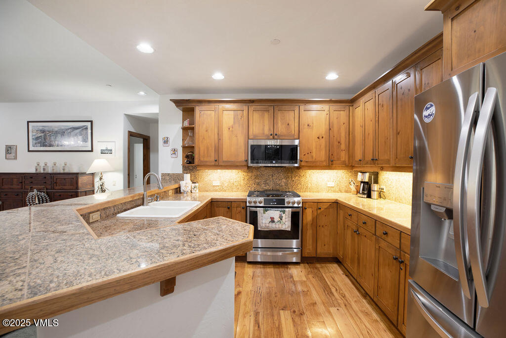 160 Cresta Road, Unit R202 Edwards, CO 81632 - Photo 4 of 25 a large kitchen with stainless steel appliances granite countertop a stove a sink and a refrigerator