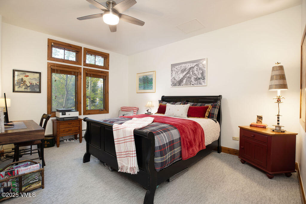160 Cresta Road, Unit R202 Edwards, CO 81632 - Photo 10 of 25 a spacious bedroom with a bed and a chandelier