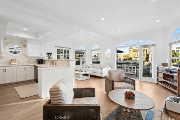 a living room with furniture white walls and kitchen view