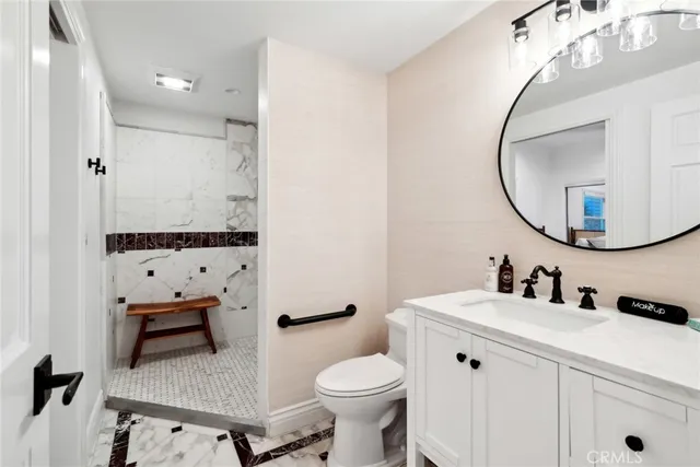 a bathroom with a sink a toilet and a mirror