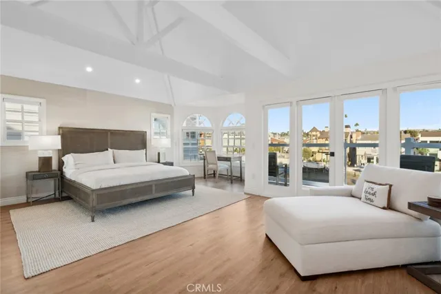 a bedroom with a large white bed couches with white walls
