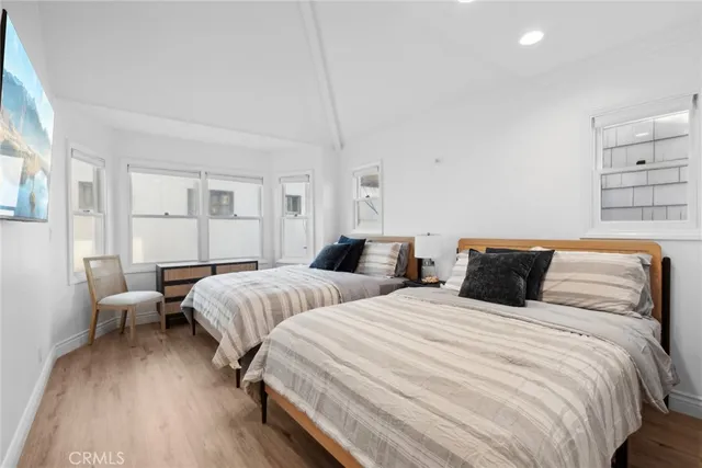 a bedroom with two beds and painting on the wall