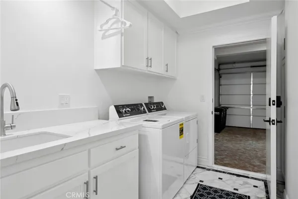 a utility room with cabinets washer and dryer