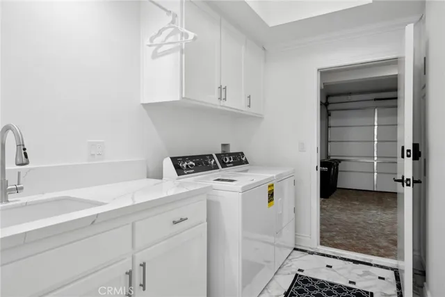 a utility room with cabinets washer and dryer