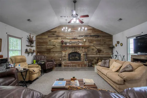 a living room with furniture a fireplace and a chandelier