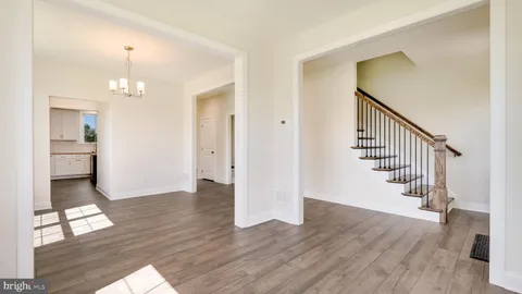 a view of empty room with a window and wooden floor