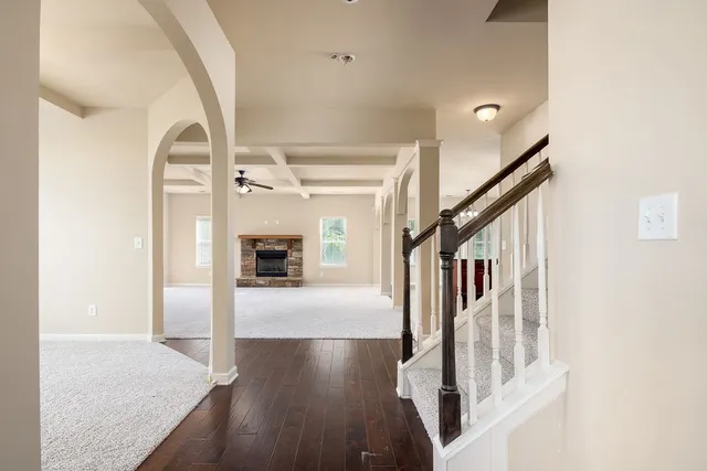 a view of a hallway with wooden floor and staircase