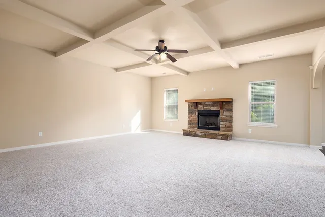 an empty room with fireplace and windows