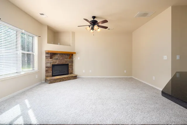 a view of a livingroom with a ceiling fan and fireplace