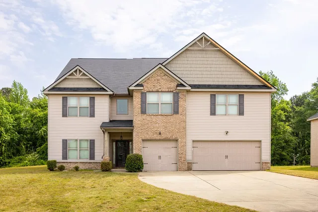 a front view of a house with a garden