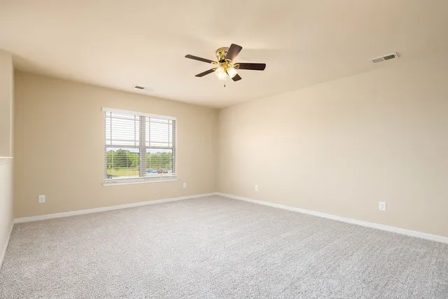 a view of a livingroom with a ceiling fan and window
