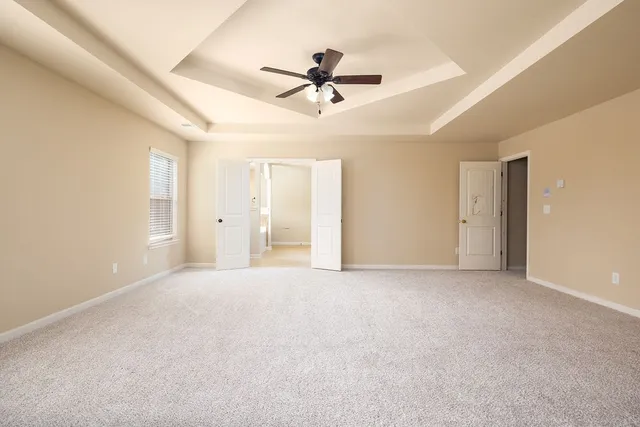 a view of an empty room with a ceiling fan
