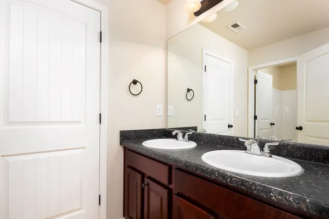 a bathroom with a granite countertop sink and a mirror