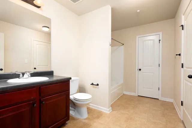 a bathroom with a toilet a sink and mirror