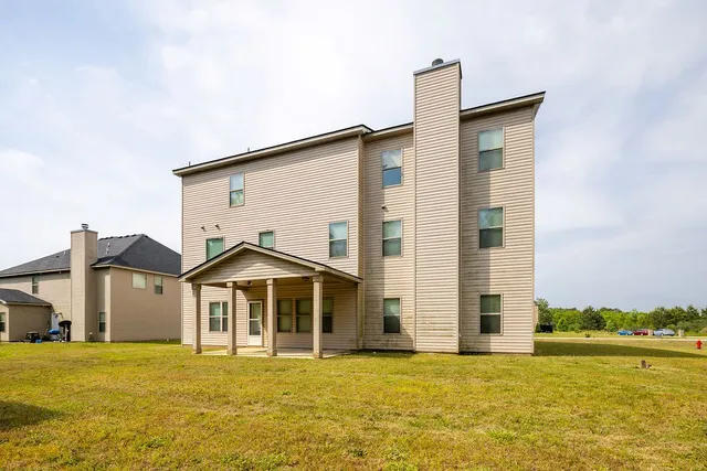 a front view of a house with a yard and ocean view