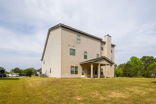 a front view of a house with a yard and lake view