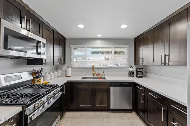 a kitchen with stainless steel appliances a sink stove and cabinets