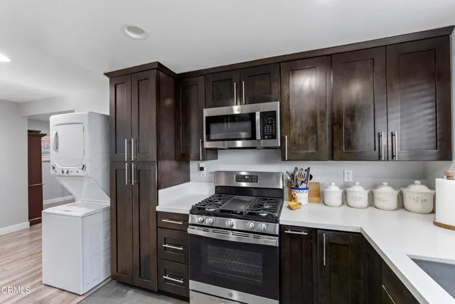 a kitchen with stainless steel appliances granite countertop a refrigerator and a stove top oven
