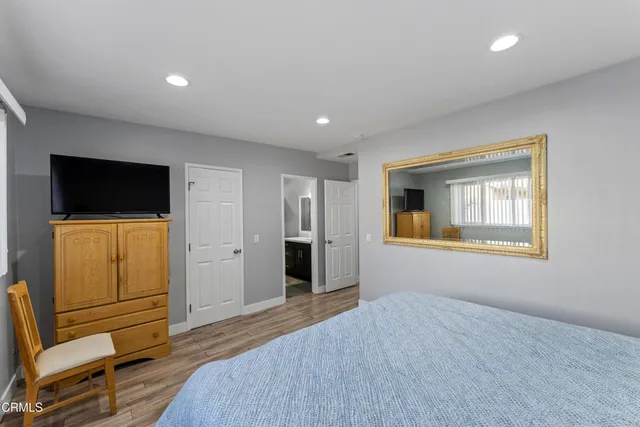 a bedroom with a bed and wooden floor